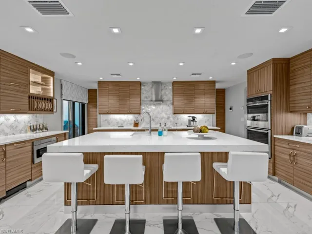 Breakfast bar with quartzite countertop and kitchen with LED lighting
