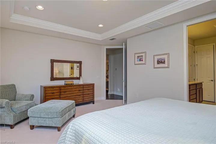 Carpeted bedroom with crown molding and a tray ceiling