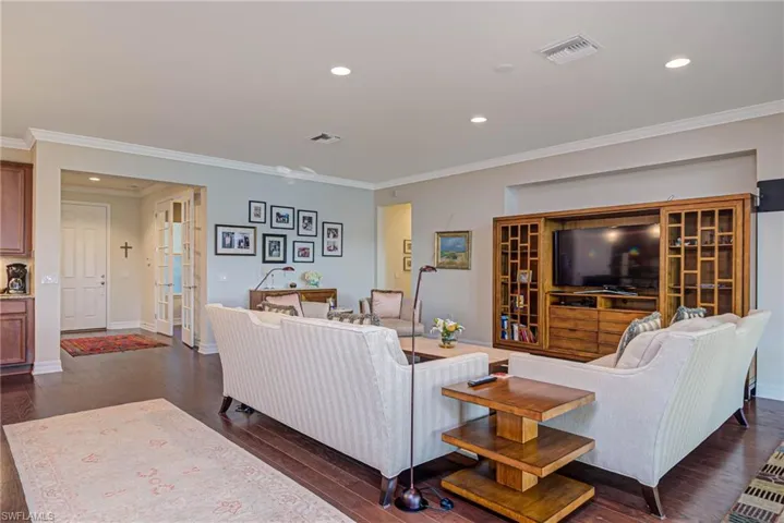 Living room featuring crown molding and dark hardwood / wood-style flooring