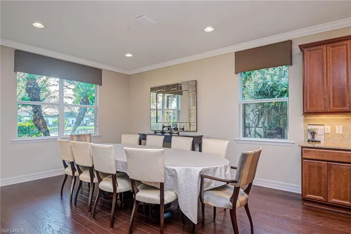 Dining space featuring crown molding, dark hardwood / wood-style flooring, and a wealth of natural light