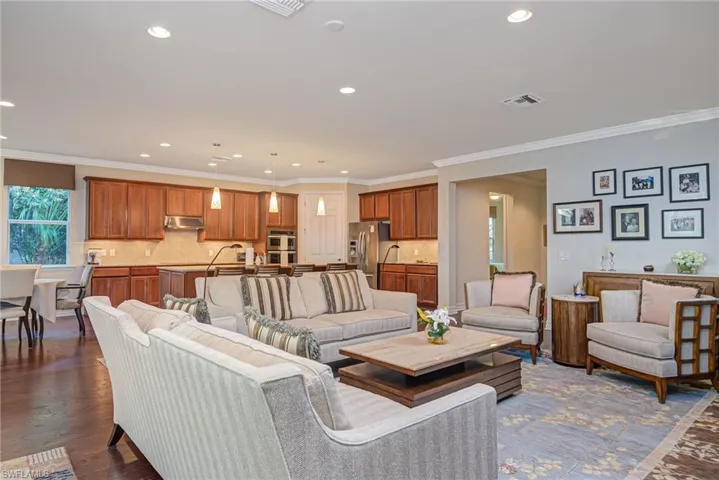 Living room with dark wood-type flooring and crown molding