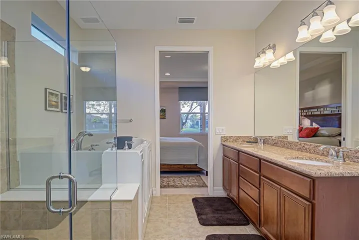 Bathroom with vanity, tile patterned floors, and a shower with door