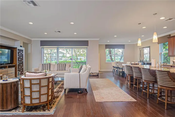 Living room with dark hardwood / wood-style flooring and ornamental molding