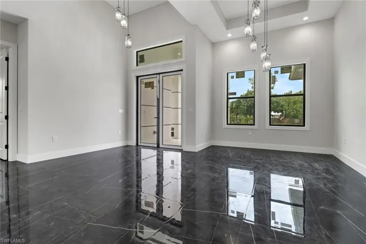 Entry featuring a high ceiling, tile flooring, and modern lighting