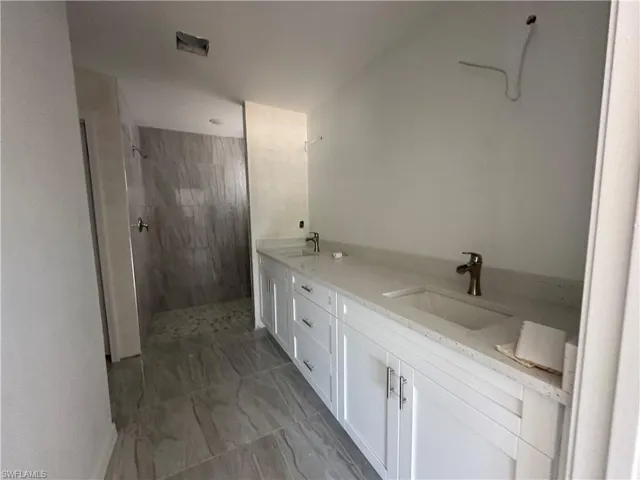 Bathroom featuring tiled shower, tile flooring,