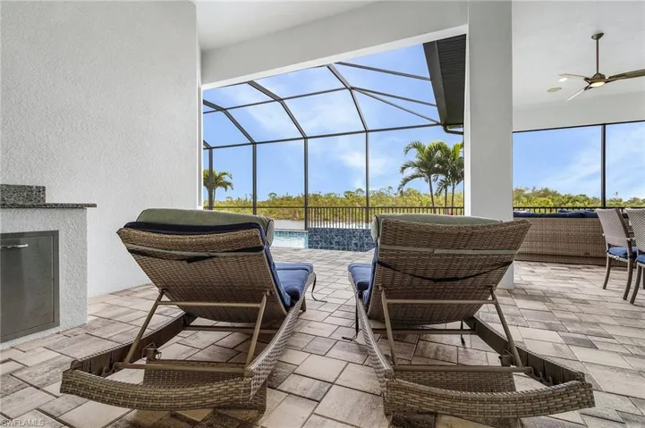 View of patio with ceiling fan and glass enclosure