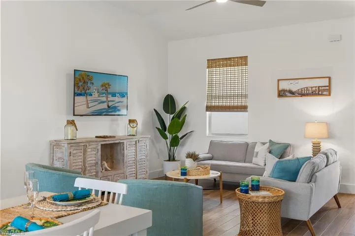 Living room featuring wood finished floors, a ceiling fan, and vaulted ceiling