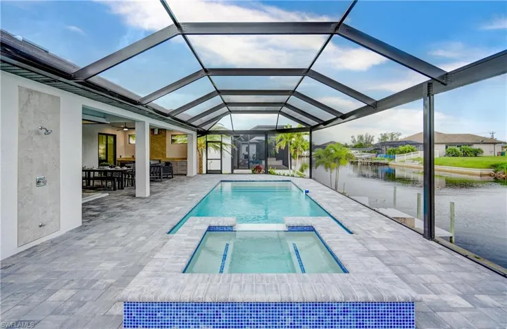 View of pool with ceiling fan, a patio area, and a lanai