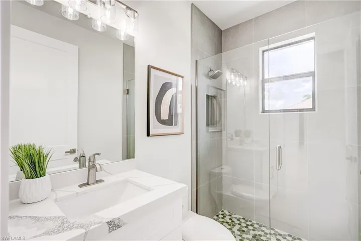 Bathroom featuring vanity, toilet, and walk in shower
