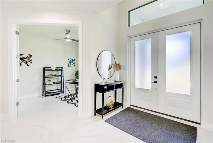 Foyer and Den, featuring French doors, ceiling fans, and tile patterned flooring.