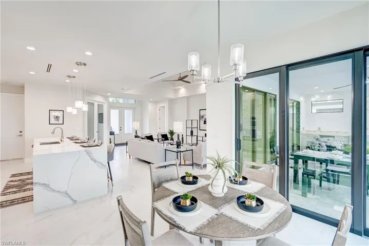 Tiled dinning space featuring an inviting chandelier, sink, and french doors