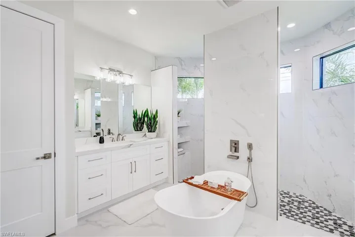 Bathroom with vanity, shower with separate bathtub, tile patterned flooring, and tile walls