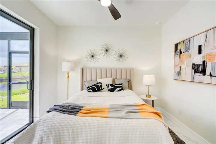 Bedroom with access to outside, multiple windows, and ceiling fan