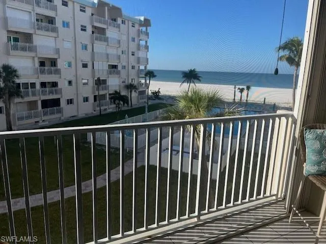 Balcony featuring view of water and beach
