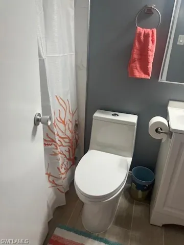 Full bathroom with vanity, a shower with shower curtain, and wood finished floors