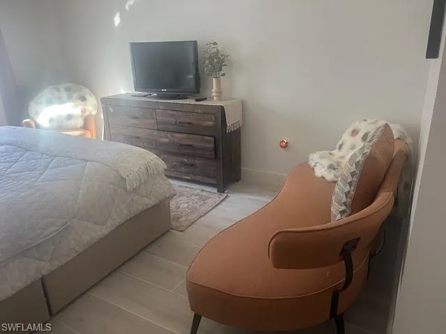 Bedroom featuring wood finished floors and baseboards