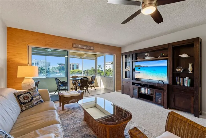 Living room featuring carpet, a textured ceiling, and ceiling fan