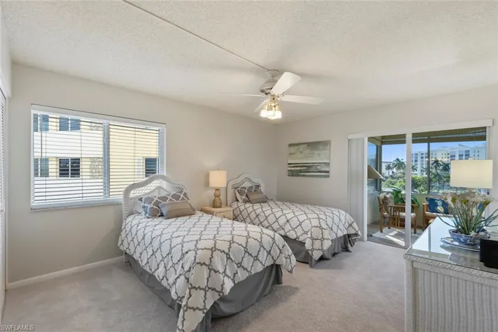 Bedroom with carpet, access to exterior, a textured ceiling, a ceiling fan, and a closet