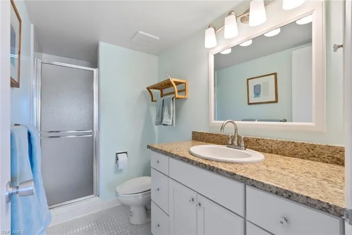 Full bath with vanity, a stall shower, and light tile patterned floors