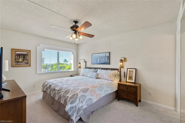 Bedroom with carpet flooring, a textured ceiling, and a ceiling fan