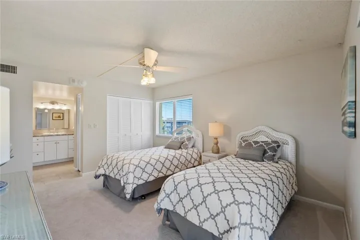 Bedroom featuring light colored carpet, a closet, ceiling fan, and a textured ceiling