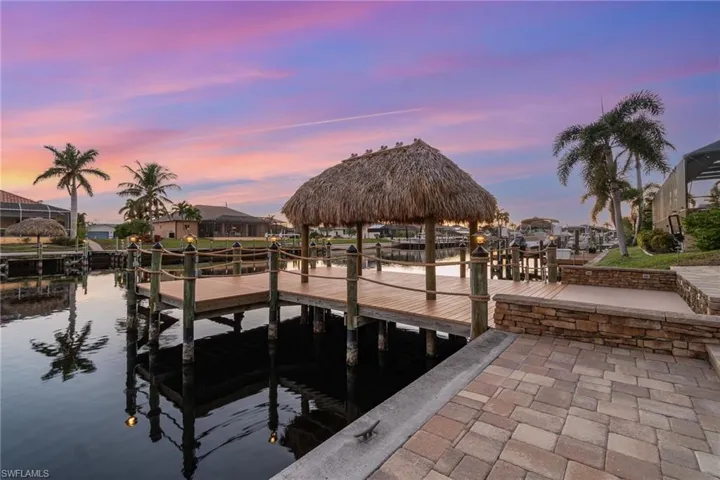 View of dock with a tiki hut and a water view