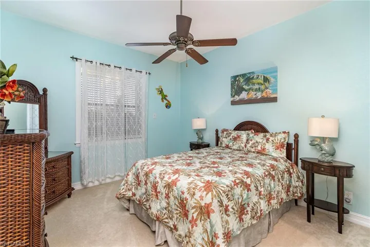 Carpeted bedroom featuring ceiling fan
