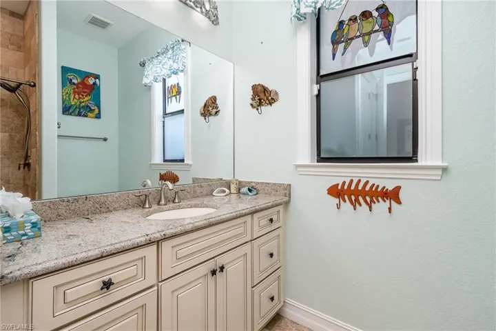 Bathroom with tiled shower and vanity