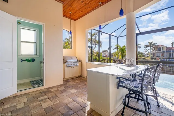 View of  lanai featuring area for grilling, eating, sitting and entertaining.  Pool bath accessible from lanai