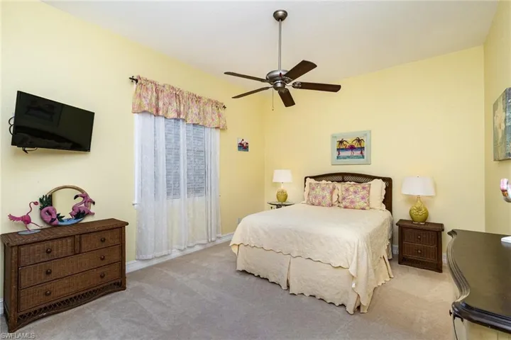 Carpeted bedroom featuring ceiling fan