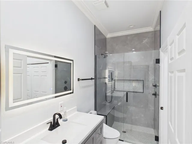Contemporary bathroom featuring a spacious glass-enclosed shower with a built-in bench and a tiled niche