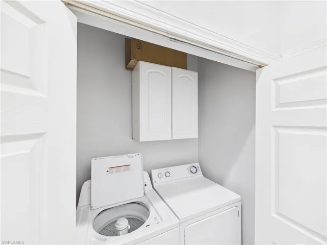 Dedicated laundry area with white cabinetry and light gray walls