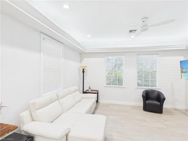 Living area featuring recessed lighting, a modern ceiling fan, crown molding, two windows with blinds, and light-toned tile flooring