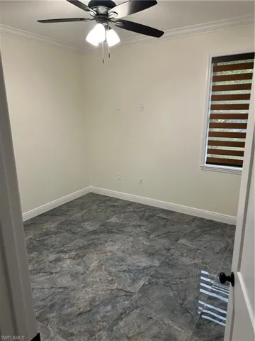 Spare room featuring ornamental molding and ceiling fan