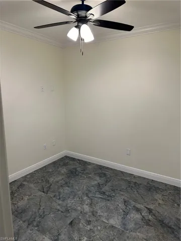 Spare room featuring ornamental molding and ceiling fan