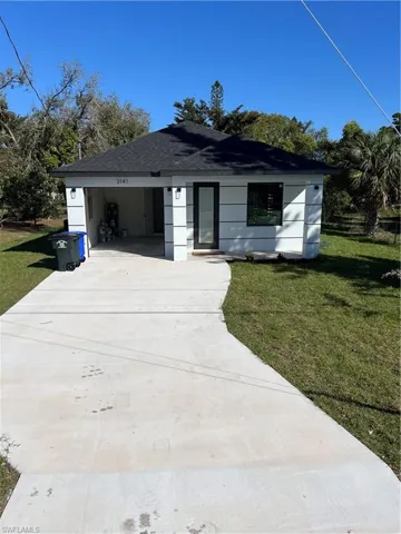 Single story home with concrete driveway, a front lawn, a shingled roof, and a garage