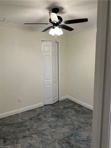 Empty room with ornamental molding and ceiling fan