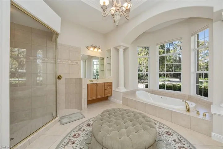 Full bathroom with a stall shower, a bath, vanity, light tile patterned flooring, and built in shelves