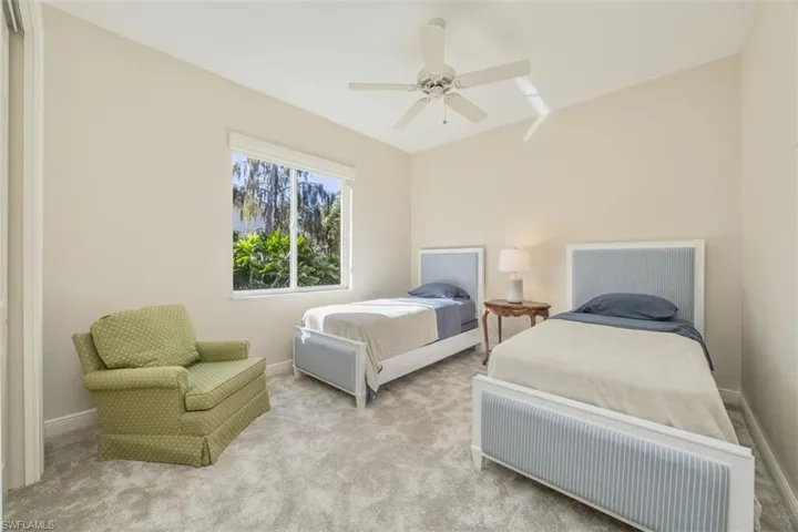 Carpeted bedroom with a ceiling fan and baseboards