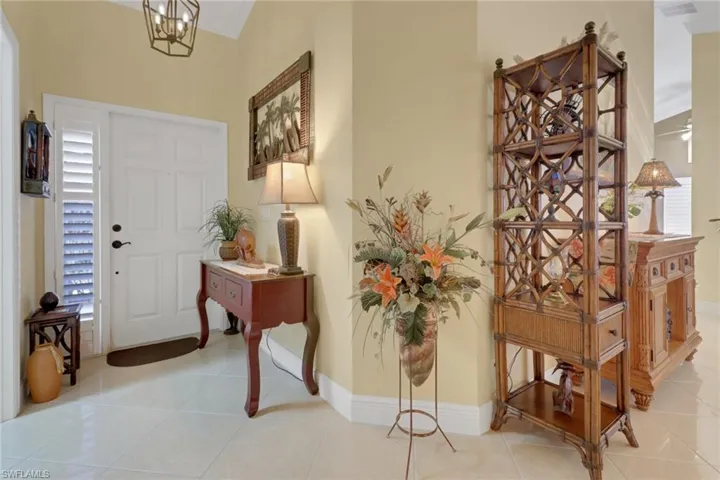 Tiled entrance foyer with a notable chandelier and ornamental molding