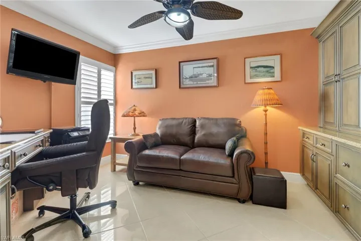 Office space with ceiling fan, light tile patterned floors, and ornamental molding