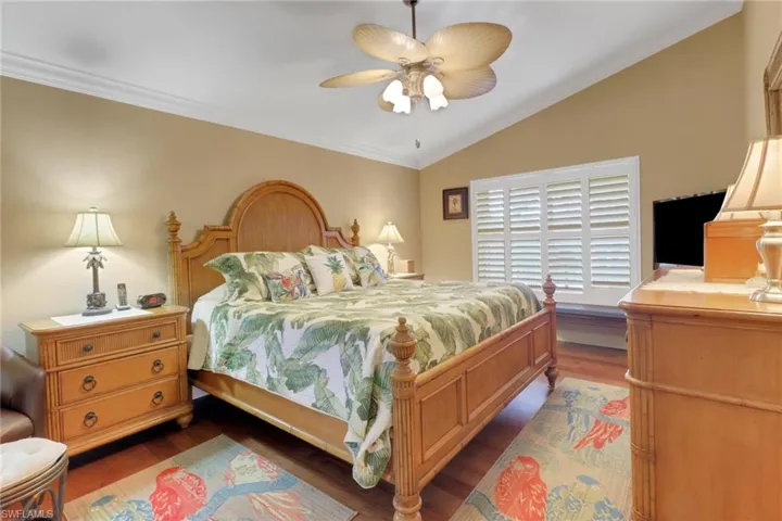 Bedroom featuring ceiling fan, dark hardwood / wood-style flooring, and ornamental molding