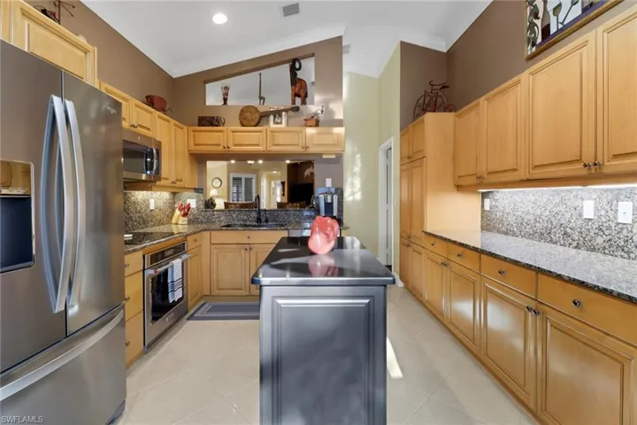 Kitchen with a kitchen island, sink, crown molding, and stainless steel appliances