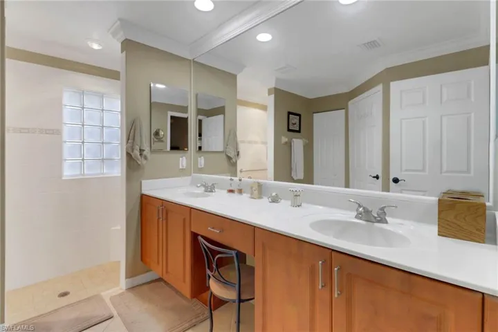 Bathroom featuring walk in shower, tile patterned flooring, vanity, and ornamental molding