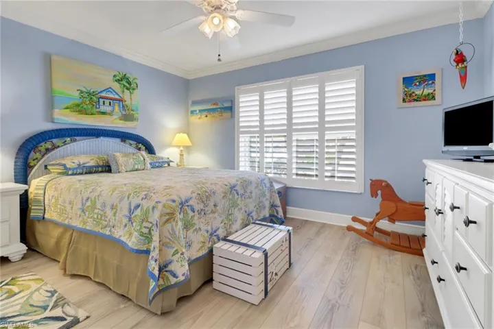 Bedroom featuring ornamental molding, light hardwood / wood-style floors, and ceiling fan