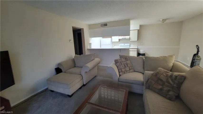 Living room featuring a textured ceiling and carpet floors
