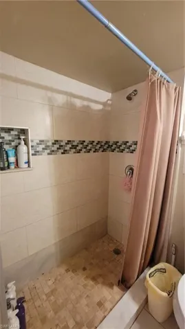 RECENTLY REMODELED bathroom with curtained shower and toilet