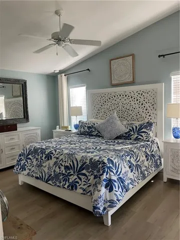 Bedroom with vaulted ceiling, dark wood finished floors, and a ceiling fan