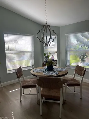 Dining area with wood finished floors and hanging lights