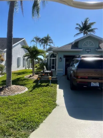 View of home's exterior featuring an attached garage, a lawn, driveway, and stucco siding